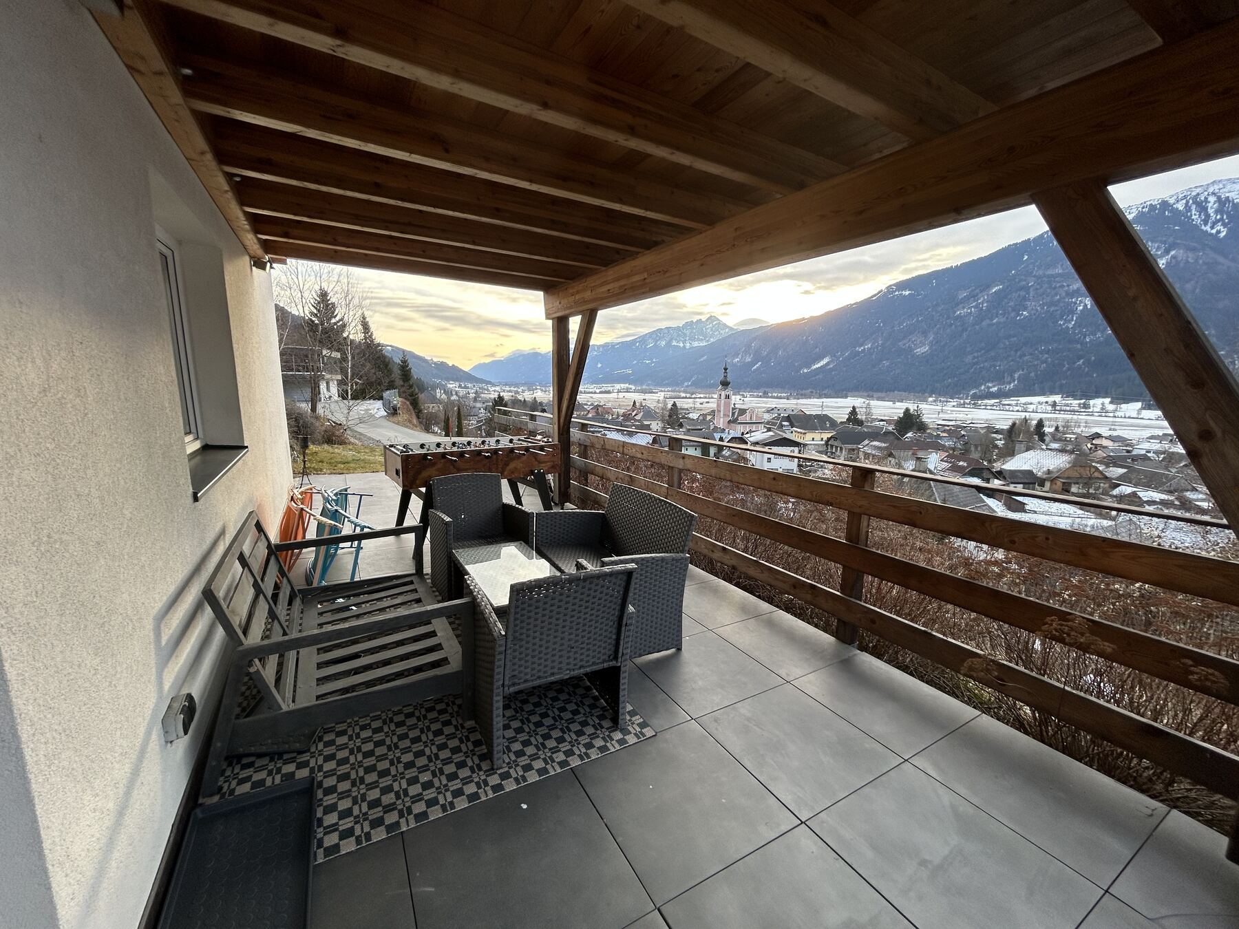 Überdachte Terrasse mit Lounge-Möbeln und Blick über das Gailtal auf die Karnischen Alpen